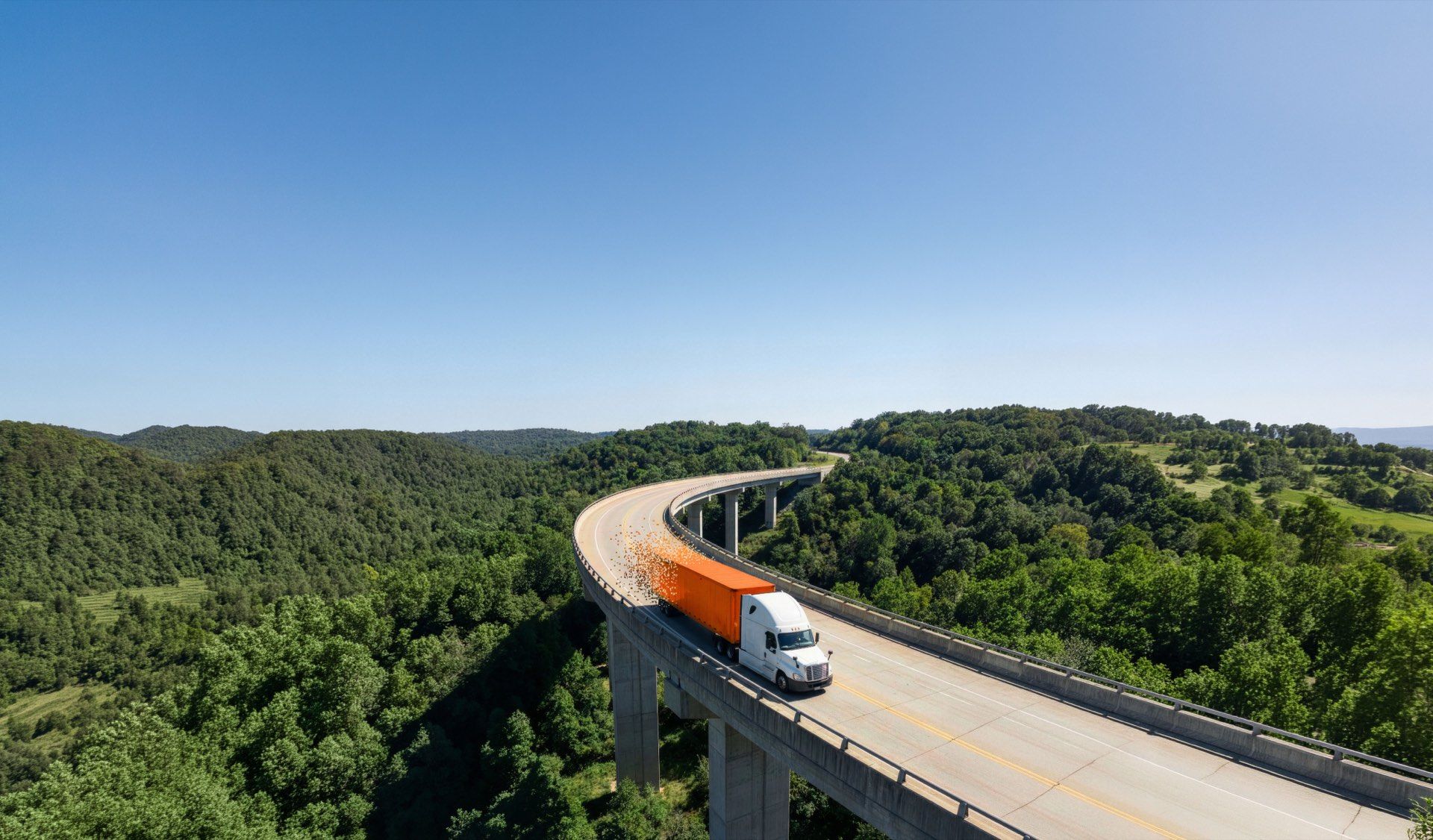 A truck crossing a highway bridge at dusk